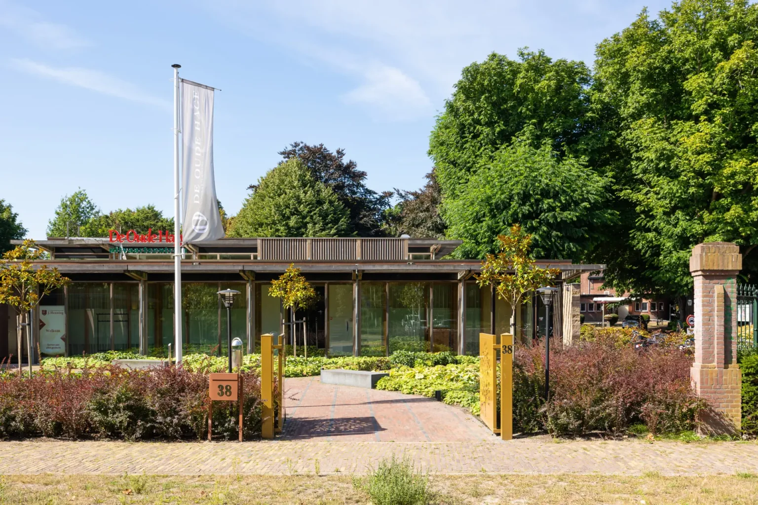 Uitvaartcentrum De Oude Hage van J. Henning in Den Haag, modern gebouw met veel glas en groen