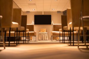 Aula met stoelen en spreekplek in uitvaartcentrum Haarlem