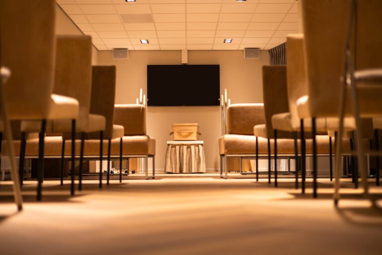 Aula met stoelen en spreekplek in uitvaartcentrum Haarlem