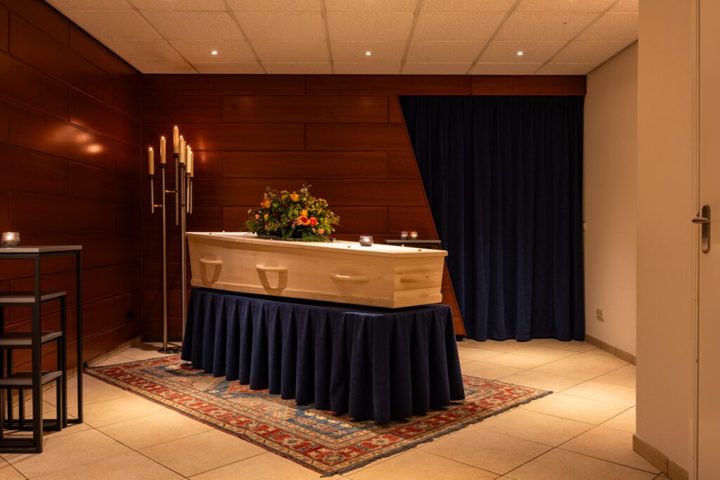Uitvaartkist met bloemen tijdens ceremonie in Aalsmeer