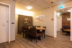 Ontvangstruimte met tafel en stoelen in uitvaartcentrum Zuid