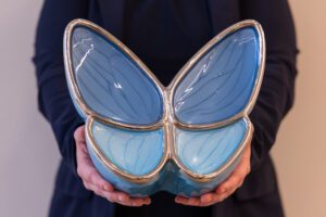 Vlinder urn in handen voor persoonlijke uitvaart