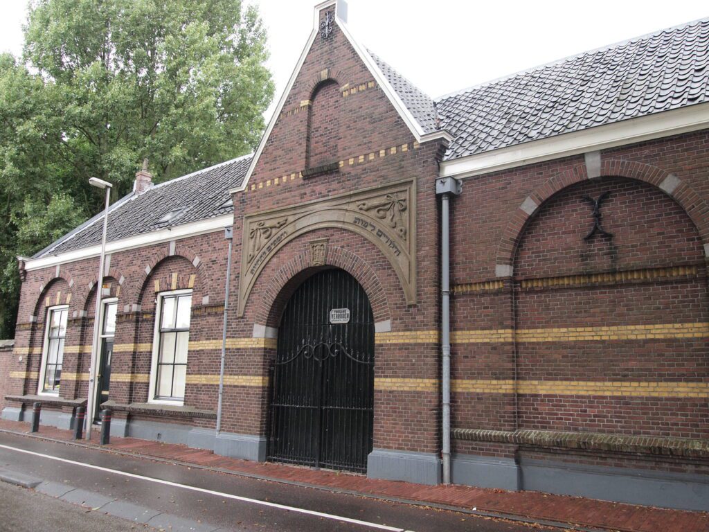 Joodse Uitvaart in Utrecht - Historisch bakstenen poortgebouw met toegangshek bij begraafplaats voor afscheid en uitvaartzorg