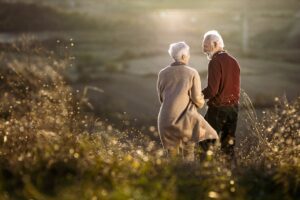 Oudere man en vrouw lopen samen in park bij afscheid
